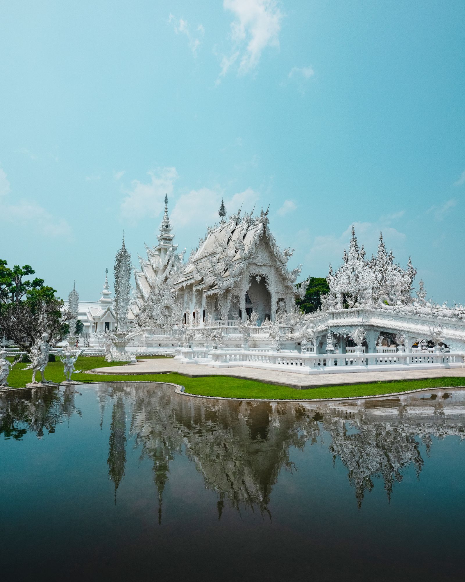 El templo blanco Wat Rong Khun y su reflejo en el agua, en Chiang Rai