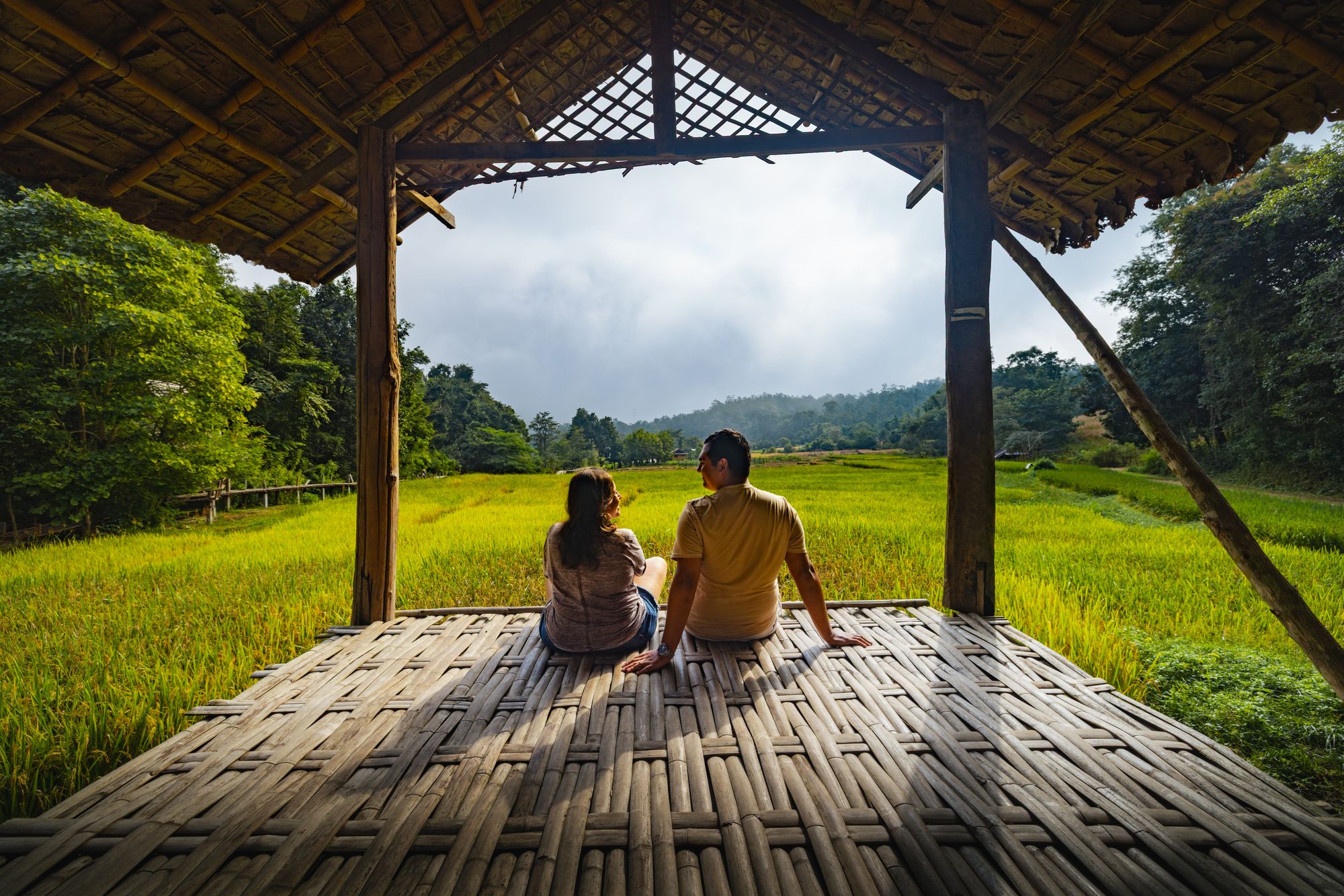 Dos viajeros contemplan un arrozal en Pai, Tailandia